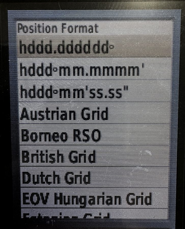 The position format list on a Garmin GPSMAP 64st, showing entries written as notation such as hddd.ddddd degrees and hddd degrees mm.mmm minutes, followed by national grid systems.